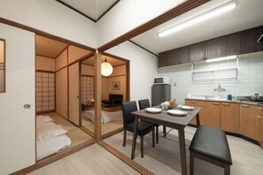 A compact living space with a dining area, kitchenette, and a traditional Japanese room. - Kiyomizu Dongurian (Kyoto)