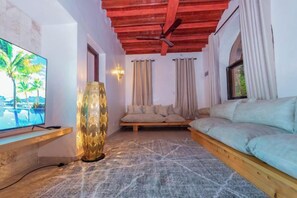 A living room with a television, a patterned floor, a sofa, and a decorative lamp. - Jandi Diani (Diani Beach)
