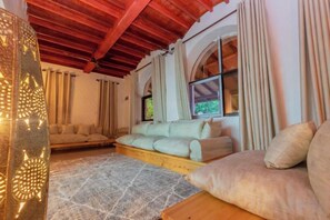 A cozy living room with a sofa set, a patterned rug, and a wooden coffee table. - Jandi Diani (Diani Beach)