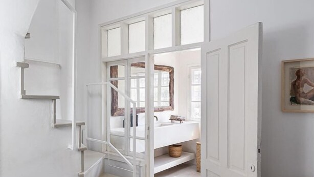A staircase leading to a bathroom with a large window, a sink, and a mirror. - The Gem of Neve Tzedek Stylish Home (Tel Aviv)