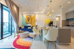 A modern living room with a sofa, coffee table, and dining area.