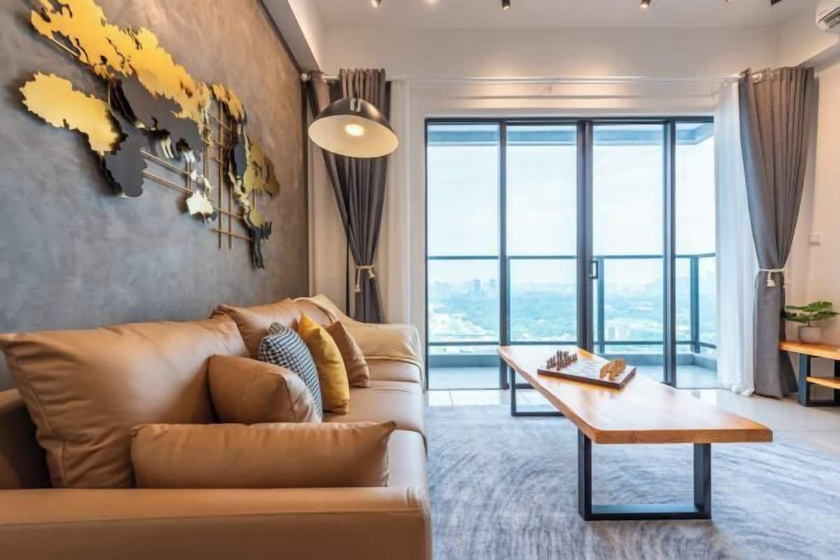 Una sala de estar moderna con un sofá de cuero, una mesa de centro de madera y un ventanal con vistas a la ciudad.