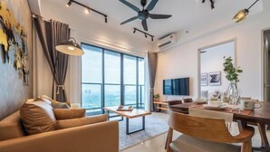 A modern living room with a sofa, dining table, and chairs, large windows, and a ceiling fan. - Trion@KL by YourSuperhost (Kuala Lumpur)