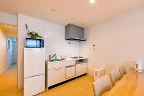 A modern kitchen with a built-in oven, a microwave, and a coffee machine. - EI･ETSU (Osaka)