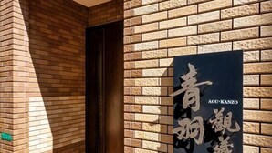 A brick wall with a sign that reads "AOU-KANZO" in English and Chinese characters. - AOU・KANZOU (Osaka)