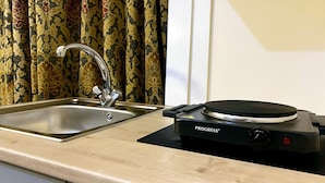 A kitchen with a sink and a black electric stove. -  Ground-Floor Super King or Twin Studio Apartment with Free Private Parking (Portsmouth)