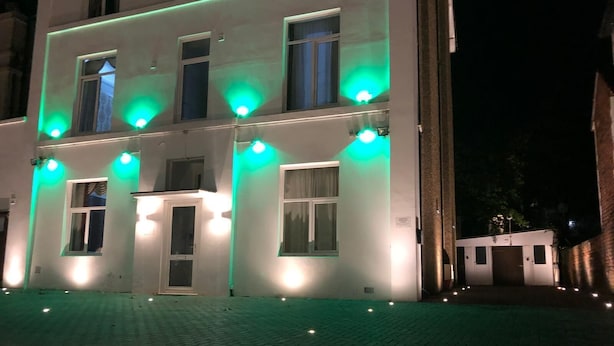 A building with multiple windows and doors, illuminated by green and white lights. -  Ground-Floor Super King or Twin Studio Apartment with Free Private Parking (Portsmouth)