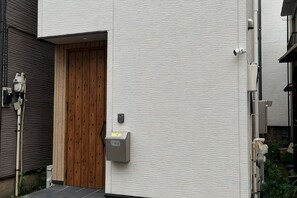 A building with a wooden door, a mailbox, and a utility box on the wall. - Higashi Mukoujima 6 chome (Tokyo)