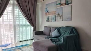 A living room with a sofa, a covered area, a large window with curtains, and wall art. - The Garden Homestay BySTAY (Sekudai)