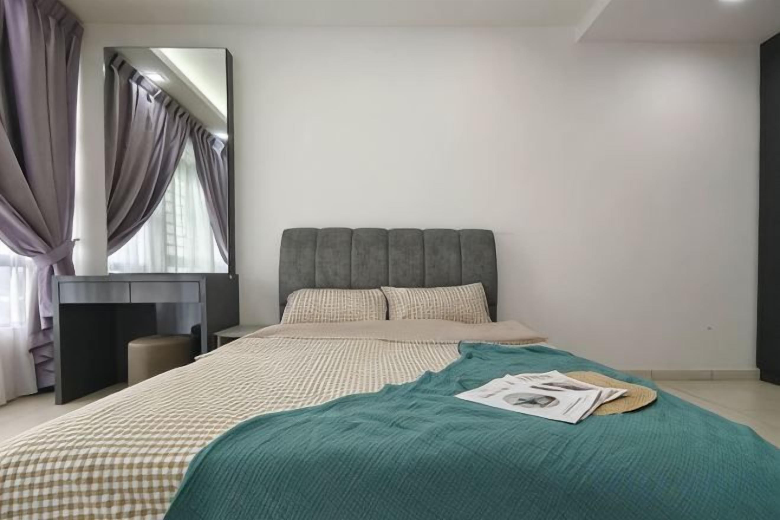 A bedroom with a bed, a bedside table, a mirror, and a window with curtains.