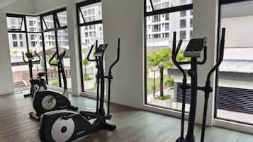 A gym with cardio equipment and large windows.