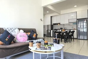 Un salon moderne comprenant un canapé, une table basse et un coin repas avec des chaises.