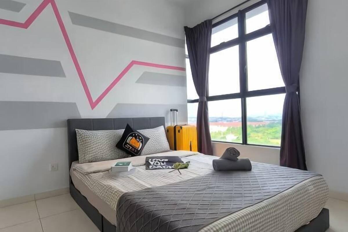 Une chambre d’hôtel avec un lit, une fenêtre avec des rideaux, une vue sur le paysage et un mur orné d’un motif géométrique.