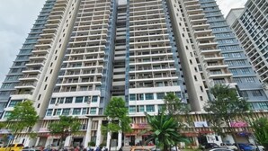 A high-rise residential building with multiple balconies, a ground-level commercial area, and a clear sky. - The Garden Homestay BySTAY (Sekudai)