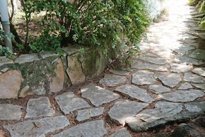 A stone pathway with irregularly shaped stones and a moss-covered rock wall. - Villa L'Ulivina - Indipendent Villa Garden & View (Sorrento)