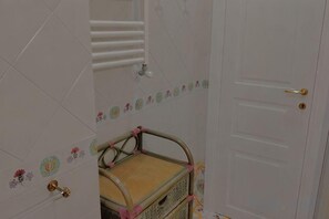 A bathroom with a white door, a shower area, and a wicker basket. - Villa L'Ulivina - Indipendent Villa Garden & View (Sorrento)