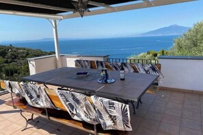 An outdoor patio with a table and chairs, a star ceiling, and a view of the sea and mountains. - Villa L'Ulivina - Indipendent Villa Garden & View (Sorrento)