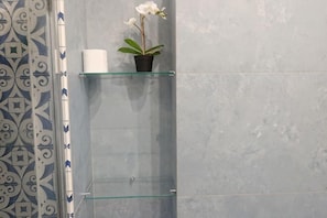 A bathroom with a patterned wall, a glass shelf with a potted plant, and a roll of toilet paper. - Villa L'Ulivina - Indipendent Villa Garden & View (Sorrento)