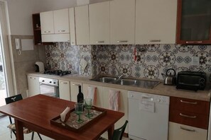 A compact kitchen with white cabinets, a stove, a sink, and a toaster. - Villa L'Ulivina - Indipendent Villa Garden & View (Sorrento)