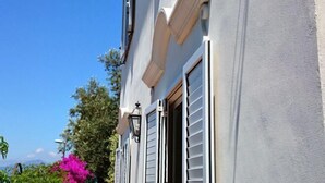 A building with a light-colored exterior, white window shutters, and a visible door. - Villa L'Ulivina - Indipendent Villa Garden & View (Sorrento)