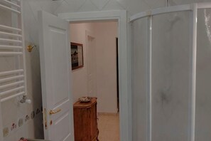 A room with a door leading to a hallway, a wooden cabinet, and a shower area. - Villa L'Ulivina - Indipendent Villa Garden & View (Sorrento)