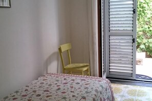 A room with a bed, a chair, and a door leading outside. - Villa L'Ulivina - Indipendent Villa Garden & View (Sorrento)