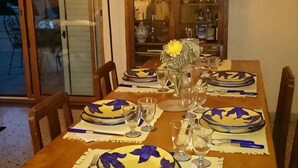 A dining table set with plates, glasses, and a vase with a yellow flower. - Villa L'Ulivina - Indipendent Villa Garden & View (Sorrento)