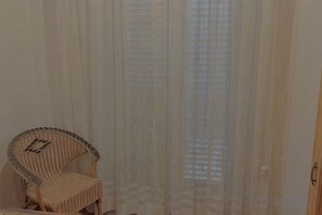 A room with a wicker chair, a window with sheer curtains, and a door. - Villa L'Ulivina - Indipendent Villa Garden & View (Sorrento)