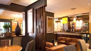 A hotel lobby with a reception desk, seating area, and a bar. - Coventry City Centre (Coventry)