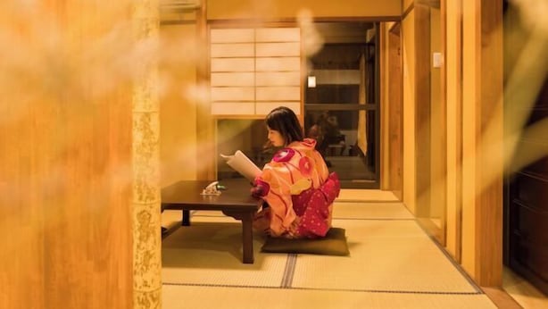 A traditional Japanese interior with tatami flooring, a low table, and a person in traditional attire. - KIRAKU・SATOZAKURA (Kyoto)