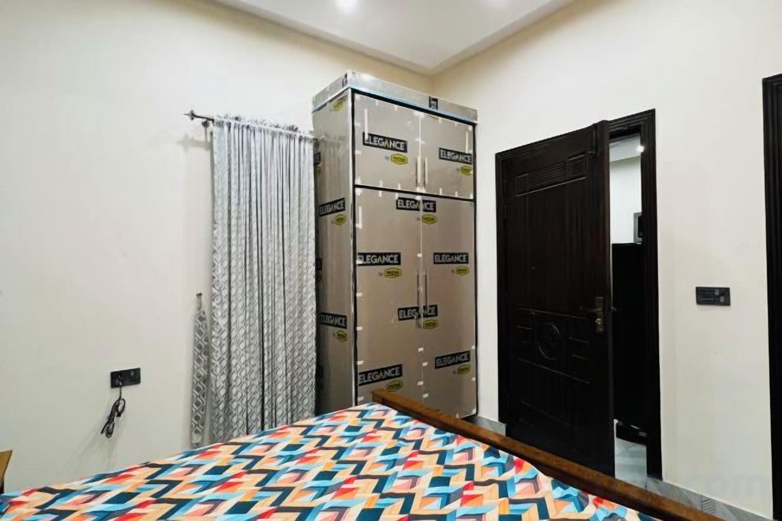 A bedroom with a bed, a wardrobe, a door, and a curtain.