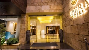 L'ingresso dell'Hotel Opera, con facciata in pietra e insegna sopra la porta.