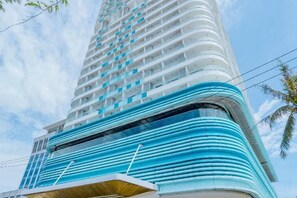 A high-rise building with a curved facade, multiple balconies, and a modern architectural design. - Tyhee Beach Apartment (Quy Nhon)