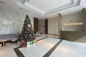 A lobby with a Christmas tree, a reception desk, and a seating area. - Tyhee Beach Apartment (Quy Nhon)