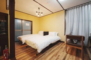 Een slaapkamer met een bed, een houten stoel, een kledingkast en een gordijn.
