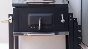 A modern, stainless steel barbecue grill with a black lid and a metal handle. - White Chocolate Pool Villa (Bang Lamung)