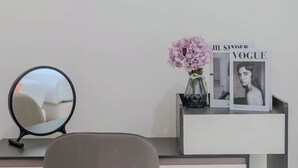 A modern vanity area with a round mirror, a vase with pink flowers, and a magazine titled 'Vogue'. - White Chocolate Pool Villa (Bang Lamung)