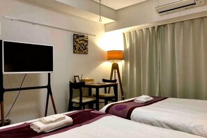 A hotel room with two beds, a desk, a chair, a TV, and a lamp. - Kinshicho 1001 (Tokyo)