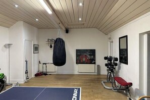 A gym with a punching bag, weight bench, and exercise equipment. - Huntershields (Northampton)