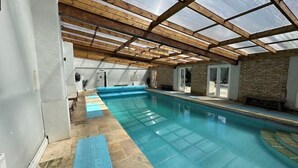 A swimming pool with a wooden ceiling and stone walls. - Huntershields (Northampton)