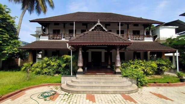 A two-story building with a central entrance and a covered porch. - Azza Heritage Home (Kochi)