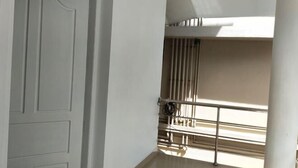 A white door with a simple design, a balcony with a metal railing, and a light-colored floor. - Azza Heritage Home (Kochi)