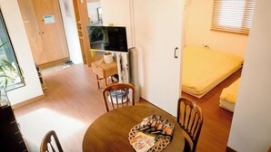 A compact living space with a dining area, a television, and a bed. - Hongdae Hanok (Seoul)