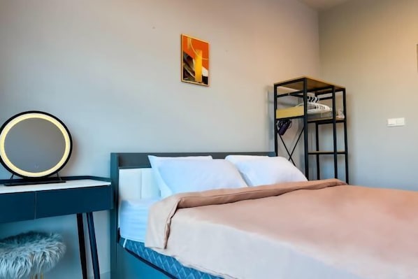 A bedroom with a bed, a desk with a mirror, and a wardrobe. - JQ Central 4 person unit facing mountain view and partially seaview AT kk CITY CENTER (Kota Kinabalu)