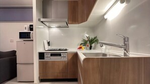 Una cocina moderna con armarios de madera, un microondas integrado, una estufa a gas y un lavamanos.