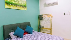 A bedroom with a bed, a grey headboard, blue pillows, a patterned bedspread, a green wall, and a window with a curtain. - Karking 15@Pinjistation (8pax/4br) (Ipoh)