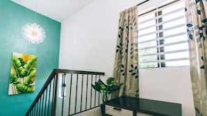 A room with a staircase, a plant, a painting, and a window with curtains. - Karking 15@Pinjistation (8pax/4br) (Ipoh)