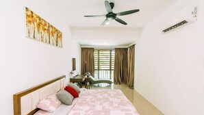 Ein Schlafzimmer mit einem Bett, einem Schreibtisch, einem Stuhl, einem Deckenventilator und einem Fenster mit Vorhängen.