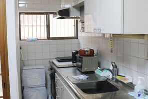 A compact kitchen with a microwave, toaster, and sink. - XUYUAN (Osaka)