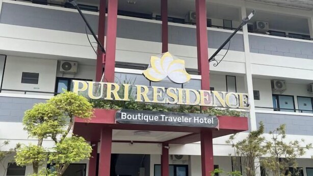The exterior of Puriresidence Boutique Traveler Hotel with a prominent sign, multiple air conditioning units, and a covered entrance area. - Puri Residence Hotel (Sananwetan)